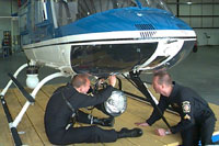 Photograph of Aviaion Pilots working On Helicopter